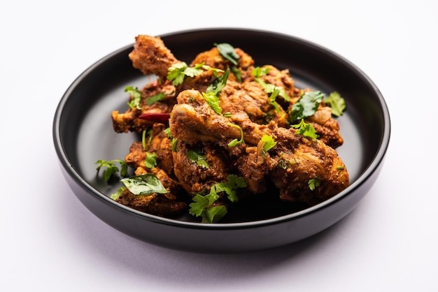 Photo sukha mutton or chicken dry spicy murgh or goat meat served in a plate or bowl