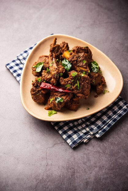 Photo sukha mutton or chicken dry spicy murgh or goat meat served in a plate or bowl