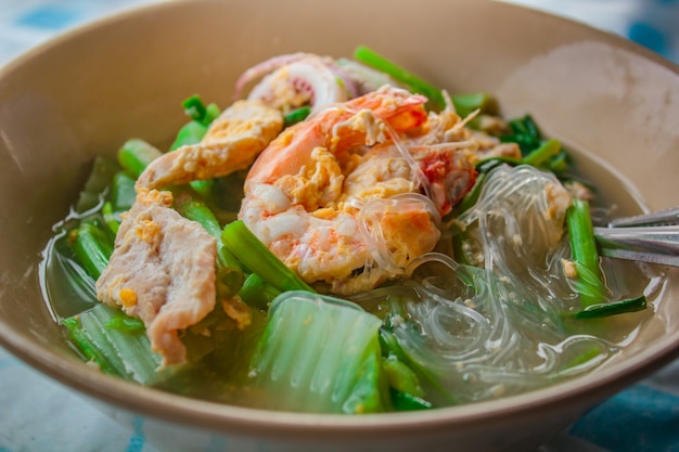 Suki in bouillon Gemengde zeevruchten met vermicelli en groenten.