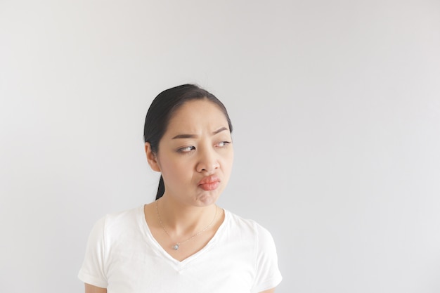 Sulk en knorrige gezichtsuitdrukking van vrouw in witte t-shirt. Concept beledigd kievish en sulky.