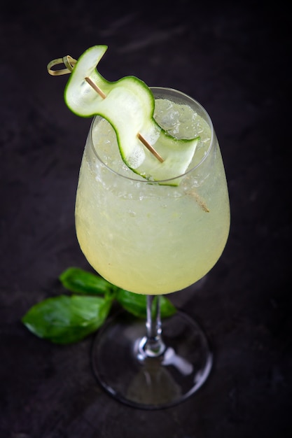 Sumer Refreshing water with cucumber and basil leaves and lime in a glass, vegetarian cocktail