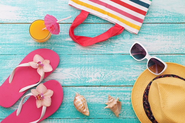 Summer accessories hat and flip-flops on wooden desk