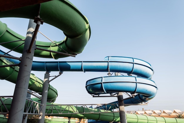 Summer aqua park with slides and colorful pipes at sunset. Sunny rest