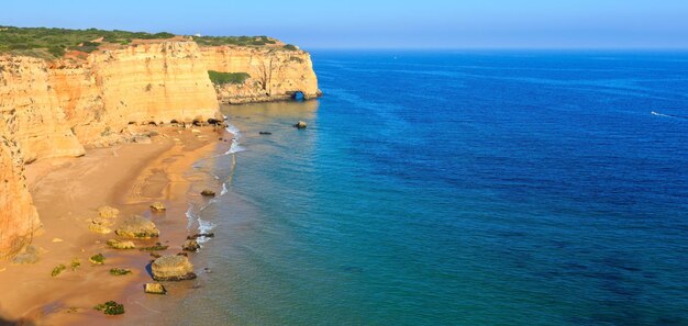 砂浜のプライアダアフラダ（ラゴア、アルガルヴェ、ポルトガル）と夏の大西洋の岩の多い海岸の景色。