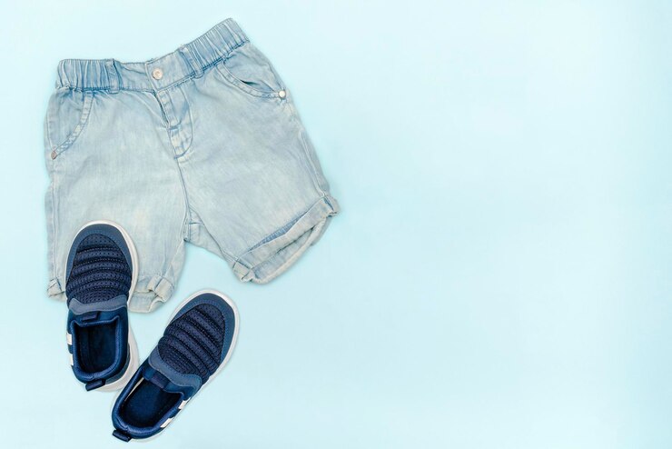 夏の赤ちゃん青い服とジーンズのショートパンツとアクセサリーモダンなファッションの子供服春または夏の子供服のセットフラットレイトップビューオーバーヘッドコピースペース付きモックアップ