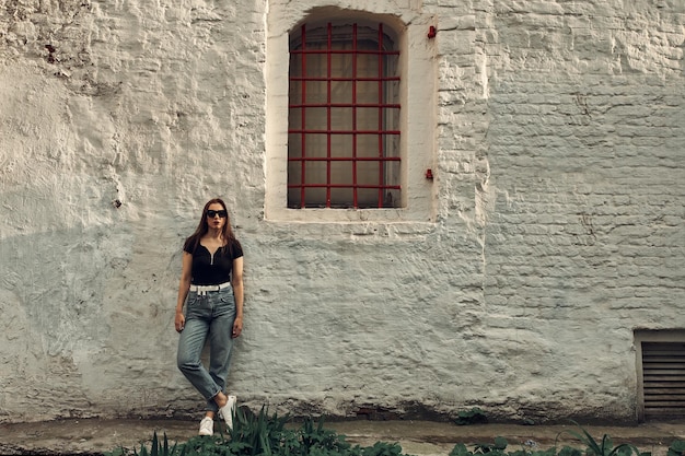 Photo summer background. beautiful young girl on the background of a city building.