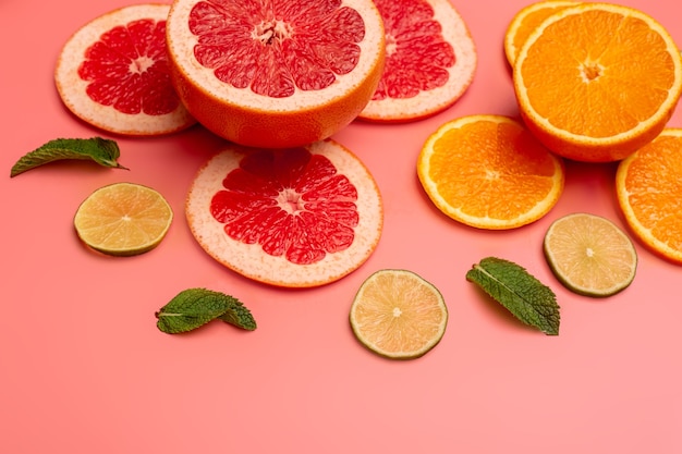 Summer background concept sliced orange, grapefruit, lemon, lime on pink and blue background