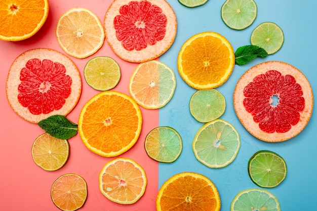 여름 배경 개념은 분홍색과 파란색 배경에 오렌지, 자몽, 레몬, 라임 슬라이스