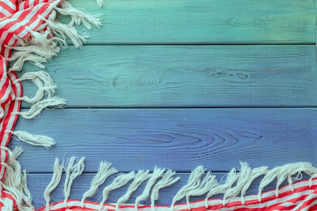 Foto pareo estivo con frange su fondo in legno blu
