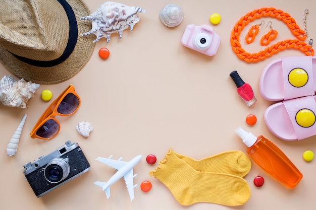 Sfondo estivo modello aereo macchina fotografica cappello da sole conchiglie ciabatte da spiaggia smalto per unghie