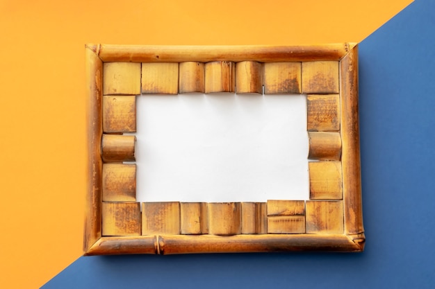 Summer background of photo frame on colored squares on orange-blue background