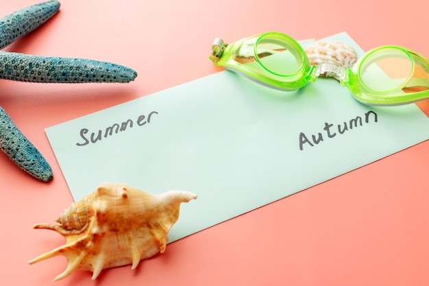 Summer background of starfish, seashells, swimming goggles and an envelope 