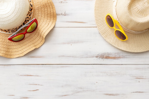 Summer background straw hats, sunglasses on a light wooden background