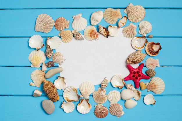 Photo summer background with the seashells and a blank note