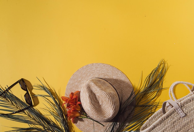 Summer background with straw hat and bag and palm leaves