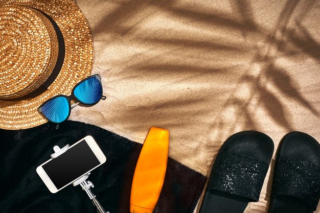 Summer background with straw hat sunglasses sunscreen bottle and flip flops