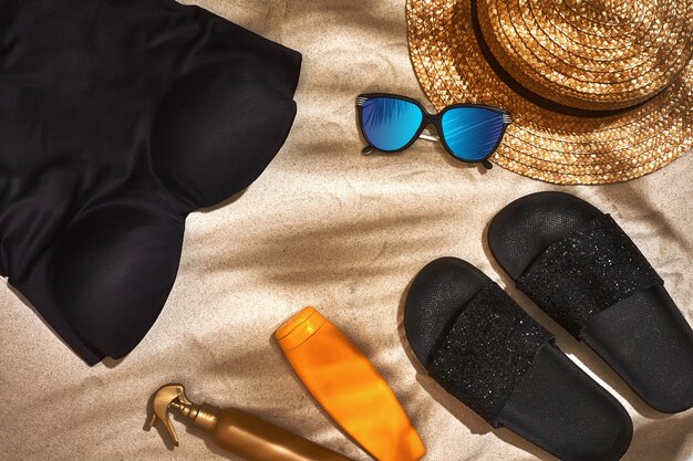 Summer background with straw hat sunglasses sunscreen bottle and flip flops