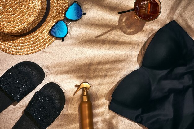 Summer background with straw hat sunglasses sunscreen bottle and flip flops