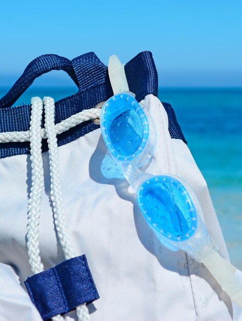 Summer bag sandals and goggles on a white shore