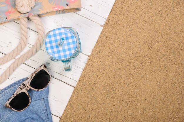 Summer beach accessories on white wood planks on the sand