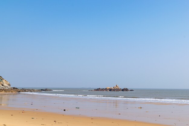 Summer beach, blue sky, golden beach and small waves