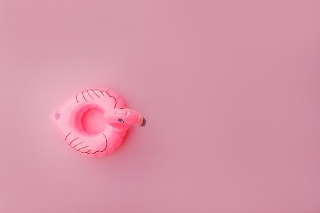 Photo summer beach composition. simply minimal design with inflatable flamingo isolated on pastel pink background. pool float party, trendy celebrity fashion concept. flat lay top view copy space.