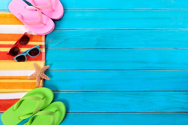 Summer beach objects border, sunglasses, flip flops, copy space