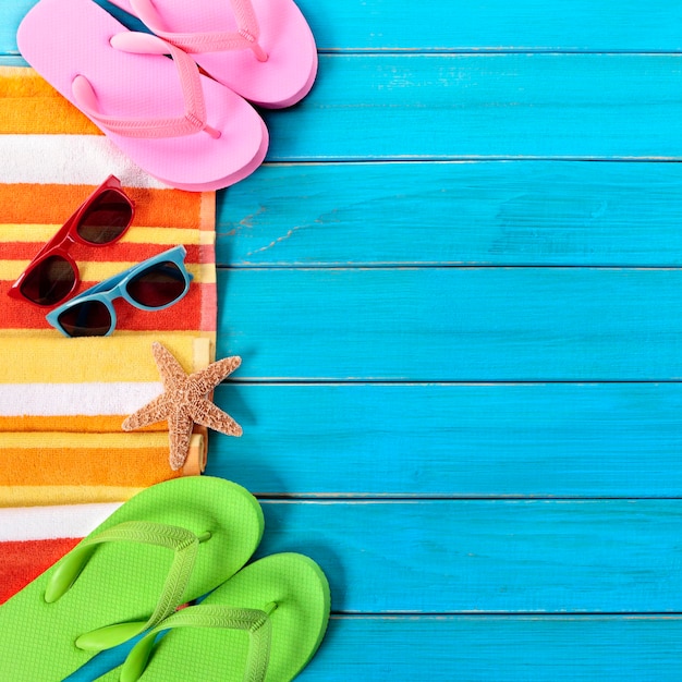 Bordo di oggetti da spiaggia estiva, occhiali da sole, infradito, spazio copia