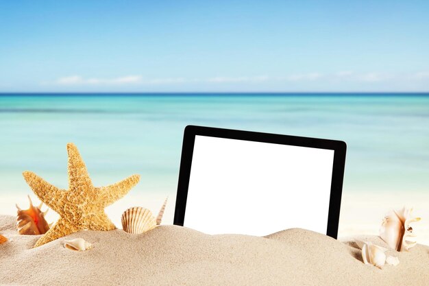 Photo summer beach with tablet in sand