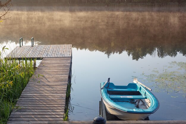 Bellissimo paesaggio estivo con barca sul lago all'alba