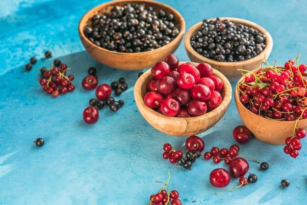 summer berries mix on blue concrete  background Blueberries red black currant and cherries