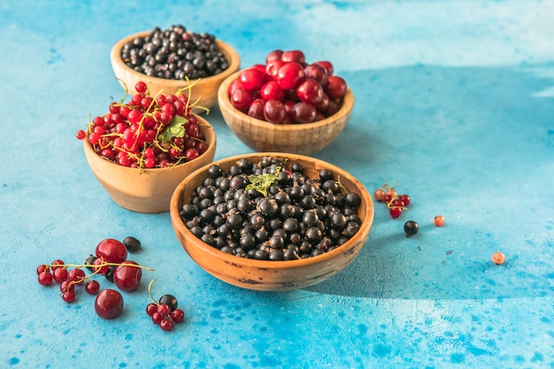 summer berries mix on blue concrete  background Blueberries red black currant and cherries