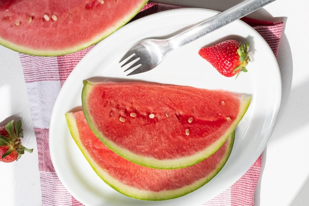 Summer berry slices of juicy watermelon on a plate on a white table