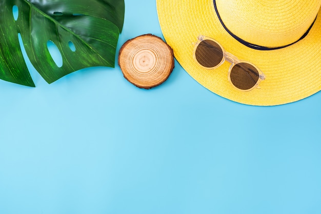 Summer blue banner with yellow hat ,sunglasses and monstera leaf on blue