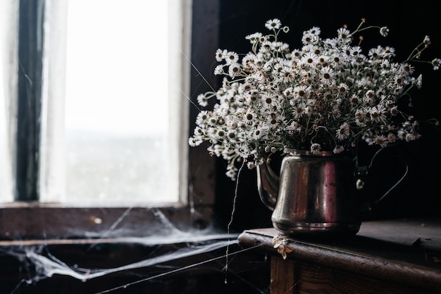 Bouquet estivo di margherite bianche in un vaso di ferro su sfondo di legno foto di alta qualità