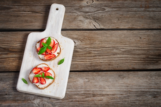 Summer breakfast bruschetta with strawberries, basil and cottage