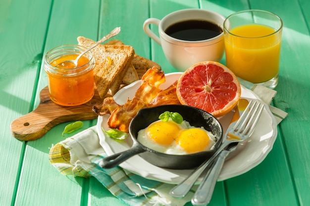 Summer breakfast - eggs, bacon, toast, jam, coffee, juice