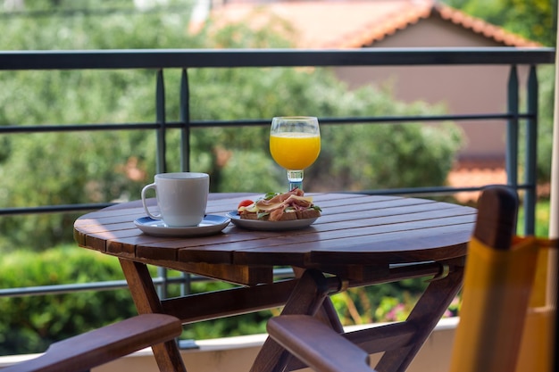 Summer breakfast outside by the ocean summer vacation in the\
hotel sandwich with coffee and orang