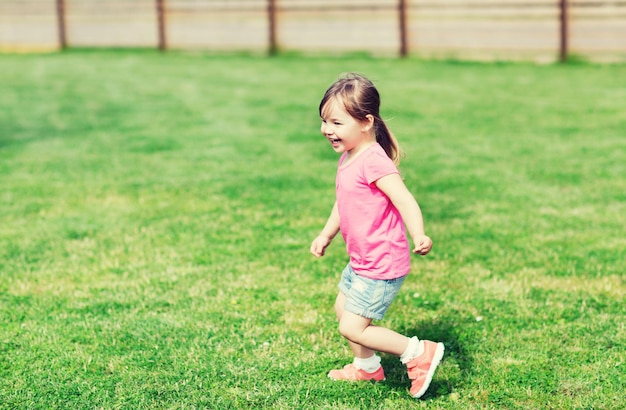 여름, 어린 시절, 여가, 그리고 사람들의 개념 - 녹색 여름 들판에서 뛰는 행복한 어린 소녀