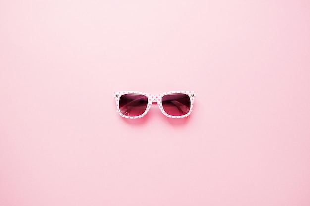 Summer childrens sunglasses on pink background