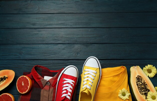 Summer clothes concept with sneakers on wooden background