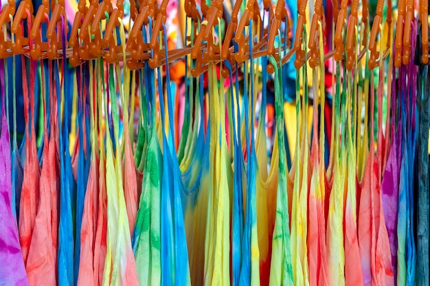 Summer clothes on hangers for sale in local street market in Thailand close up