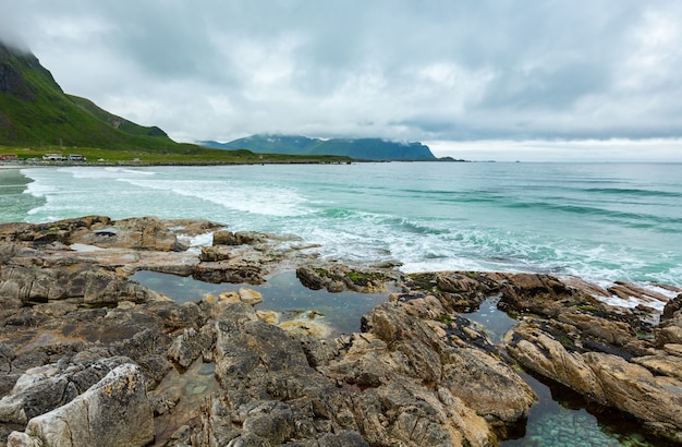 ランバーグ（ノルウェー、ロフォーテン諸島）の石のビーチの夏の曇りの景色。認識できない人々。