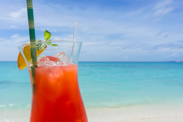 Summer cocktail against tropical sea and sky background