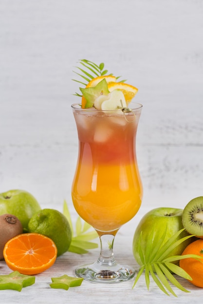 Summer cocktail with various tropical fruits around