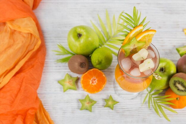 Summer cocktail with various tropical fruits around