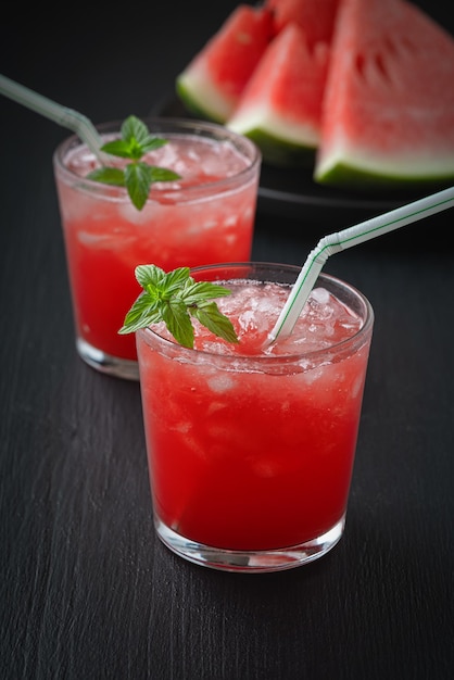 Summer cold drink with watermelon and mint on a black wooden background