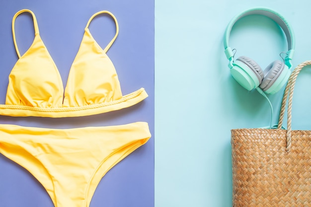 Летняя коллекция, бикини желтого цвета, наушники и соломенная пляжная сумка. летний отпуск