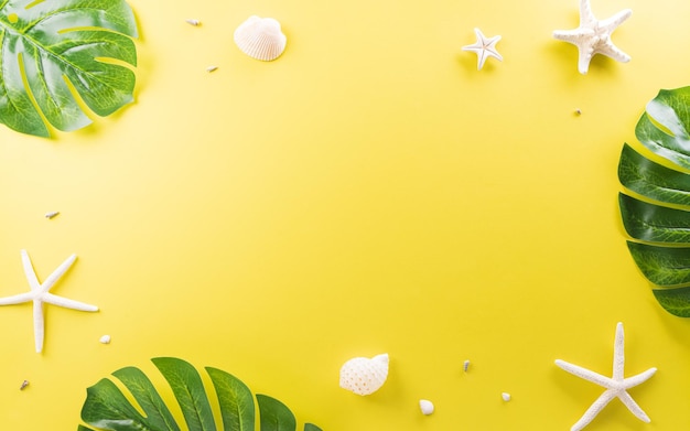 Summer composition concept made from starfish shell and monstera leaf on yellow background