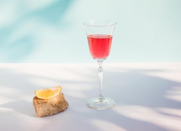 Summer composition with red beverage Lemon slice stone podium and shadow Summer drink concept